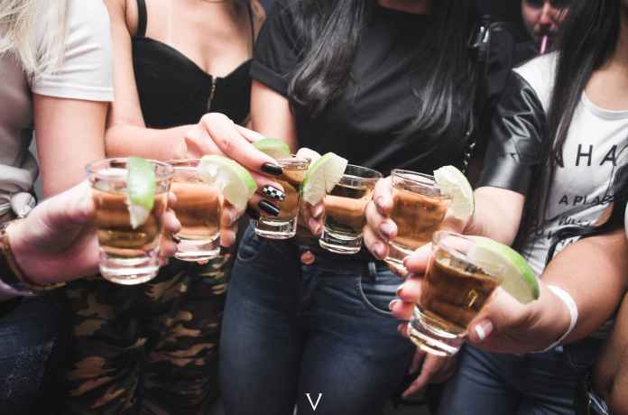 women holding shot glasses